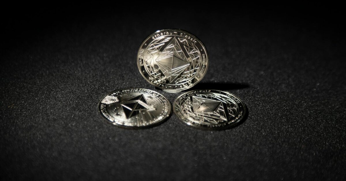 Close-up of three Ethereum coins on a dark background, showcasing digital currency themes.