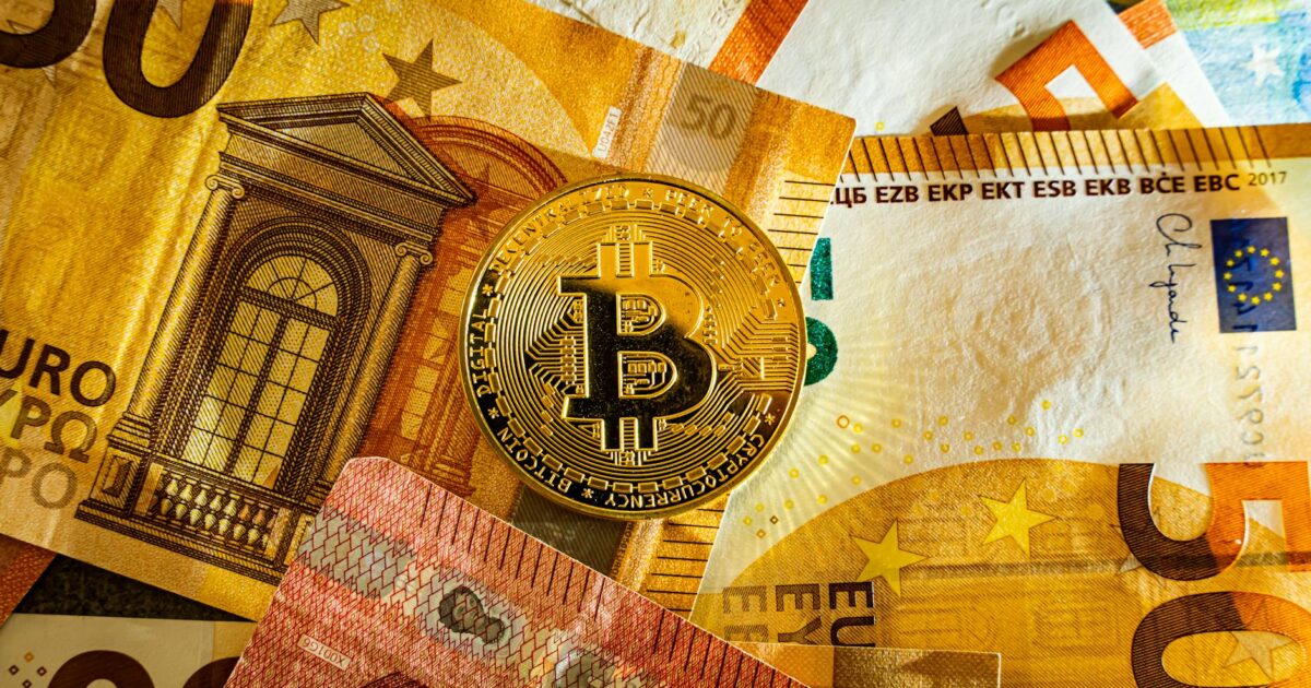 Golden Bitcoin coin placed on euro banknotes symbolizing digital currency and modern finance.
