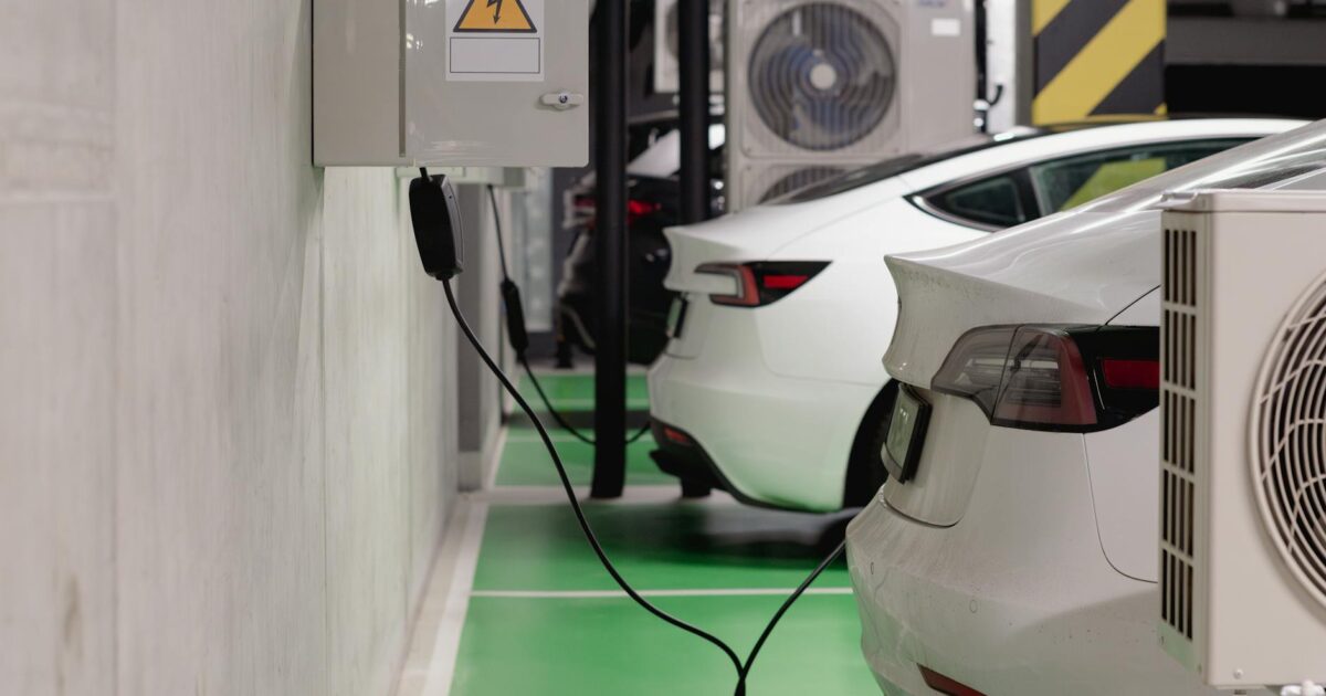 Electric vehicles charging at an indoor station in a modern underground garage.